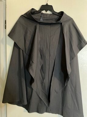 This is a gray hooded cape top with draping fabric details.